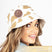 COW PRINT BUCKET HAT WITH LEATHER DIRT WARRIOR PATCH with gold camouflage pattern and 'Dirt Warrior Accessories' logo.